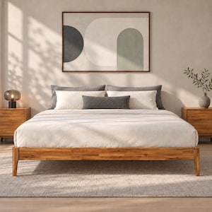 May include: A wooden bed frame with a white duvet, two large gray pillows, and a smaller dark gray rectangular pillow. The bed is flanked by two wooden nightstands, one with a glass lamp and the other with a vase of greenery.