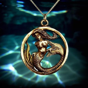 Mermaid pendant on a sterling silver chain. Hand sculpted and cast in solid bronze.  Lacquered to retain its beautiful appearance.