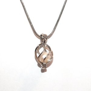 May include: A silver chain necklace with a silver cage pendant containing a white pearl.