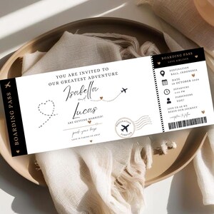 May include: A rectangular wedding invitation designed as a boarding pass with black and white text. It features the names Isabella and Lucas, the text You Are Invited To Our Greatest Adventure, and travel details for Bali, Indonesia on October 18, 2026.