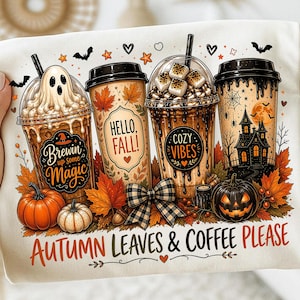 May include: A cream-colored t-shirt featuring a graphic of four coffee cups surrounded by autumn leaves, pumpkins, and a haunted house. The text reads Brewin up some Magic, Hello Fall, Cozy Vibes, and Autumn Leaves & Coffee Please.