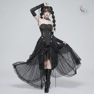 May include: A black strapless corset dress featuring a skeletal rib cage design on the bodice, a lace-up front, and a layered tulle high-low skirt with lace trim. The outfit includes matching black arm warmers and a choker, paired with black boots.