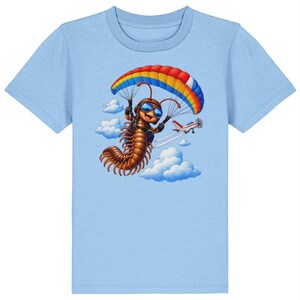 May include: A light blue t-shirt featuring a graphic illustration of a brown centipede wearing goggles and skydiving with a red, yellow, and blue parachute. A small white and red aeroplane flies in the background among fluffy white clouds.