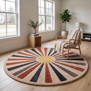 May include: A large circular area rug featuring a central yellow circle surrounded by radiating sunburst rays in alternating shades of burnt orange, dark charcoal gray, and light beige, creating a geometric pattern across the floor surface.