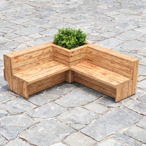 May include: An L-shaped wooden bench featuring horizontal slats and a built-in corner planter box. The bench is constructed from light brown wood with a visible grain pattern and contains a vibrant green leafy plant in the central square planter.