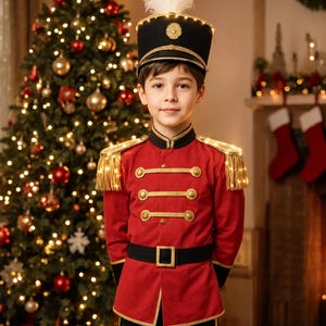 May include: A red and black military-style jacket with gold trim, gold buttons, and gold fringe epaulets featuring integrated LED lights. The outfit includes a matching black hat with a tall white feather plume and a gold emblem on the front.