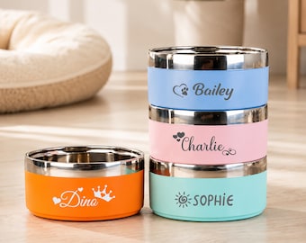 May include: Four round pet bowls with stainless steel interiors and colorful exteriors. One orange bowl is labeled Dino with a crown icon. The stacked bowls are light blue labeled Bailey with a paw, pink labeled Charlie, and teal labeled SOPHIE.