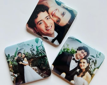 May include: Three square coasters featuring printed photographs of a couple in formal wedding attire. One coaster shows a close-up portrait, while the other two display full-length and medium shots of the pair in a lush, green indoor setting.