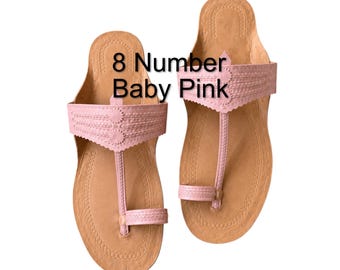 May include: A pair of baby pink sandals featuring a toe post design and a wide strap across the top with decorative stitching and scalloped edges. The text 8 Number Baby Pink is printed over the sandals, which have a tan footbed and sole.