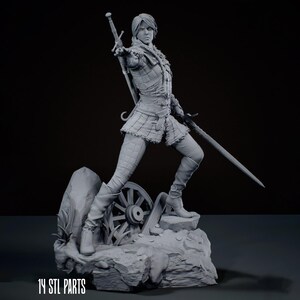 May include: A grey 3D printed figurine of a warrior in a dynamic stance, holding a sword in one hand and extending the other. The figure wears textured armour and carries a sword on their back. The base features a wagon wheel and rocks. Text reads 14 STL PARTS.