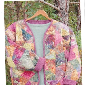 May include: A Kwik Sweatshirt Jacket pattern featuring a multi-colored patchwork design with pink, orange, yellow, and green fabric pieces. The text reads: Kwik Sweatshirt Jacket, Transform a plain sweatshirt into a work of art. Block pattern included, Two Kwik Quilters, TKQ16.