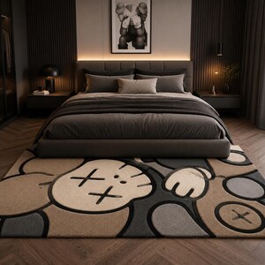 May include: A rectangular area rug featuring a large, stylized cartoon character face with X-shaped eyes and gloved hands. The design uses a muted color palette of beige, dark gray, and black, with thick black outlines defining the graphic shapes.