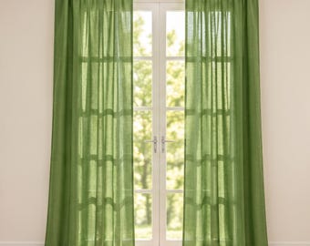 May include: A pair of floor-length, semi-sheer curtains in a solid olive green colour. The curtains feature a pleated top header and are hung on a white rod, covering a glass-paned door that allows natural light to filter through the fabric.