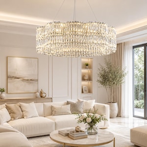 Op de afbeelding: Een grote, ronde kristallen kroonluchter met meerdere lagen van gefacetteerde glasprisma's die het licht breken. Het armatuur heeft een metalen frame, hangt aan het plafond en verspreidt een warme, heldere gloed door de kamer.