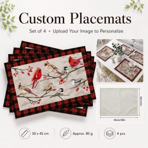 May include: A set of four rectangular placemats featuring a red and black buffalo plaid border and a central illustration of various birds perched on branches with red berries. The placemats measure 12 inches by 18 inches and weigh 80 grams each.
