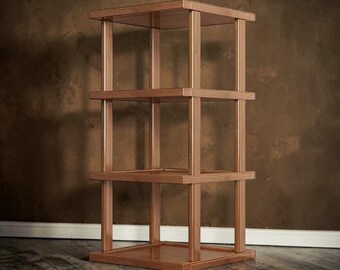 May include: A four-tier wooden shelving unit featuring a square base and three additional square shelves supported by four vertical corner posts. The structure is finished in a warm, medium-brown wood tone with a smooth, polished surface throughout.