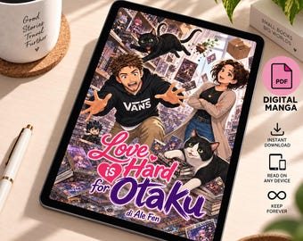 May include: A digital tablet displaying a manga cover titled Love is Hard for Otaku by Ale Fen. The artwork features a man in a black hoodie, a woman in a beige cardigan, a black cat, and a black and white cat surrounded by stacks of books.