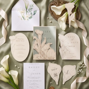 Puede incluir: Un conjunto de papeler&iacute;a de boda con ilustraciones de lirios cala en tonos crema y verde salvia. Incluye un sobre con forro floral, un men&uacute;, una tarjeta de save the date, una invitaci&oacute;n con funda troquelada, un RSVP con c&oacute;digo QR y un marcador.