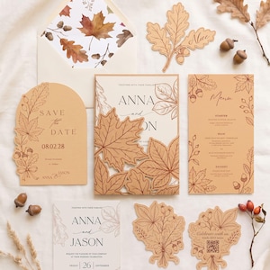 Könnte beinhalten: Ein Hochzeitspapeterie-Set aus beigem und cremefarbenem Papier mit Illustrationen von Herbstblättern und Eicheln. Enthält einen Save-the-Date-Karten-Entwurf, eine Einladung mit gestanztem Blatt-Cover, ein Menü, eine RSVP-Karte und einen Umschlag.
