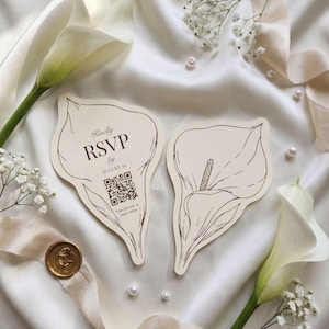 May include: Two die-cut RSVP cards shaped like calla lilies. The left card features the text "Kindly RSVP by AUGUST 10" above a QR code and the instruction "Scan QR code to reply online." The right card displays a detailed line drawing of a calla lily.