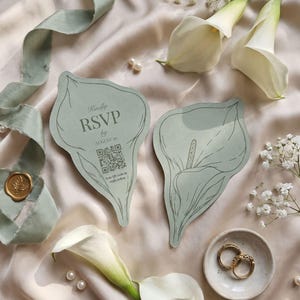 Puede incluir: Dos tarjetas de color verde salvia con forma de cala y dibujos de l&iacute;neas en verde oscuro. Una tarjeta muestra el texto 'Kindly RSVP by AUGUST 16' sobre un c&oacute;digo QR y la frase 'Scan QR code to reply online'. Las tarjetas se disponen con calas blancas.