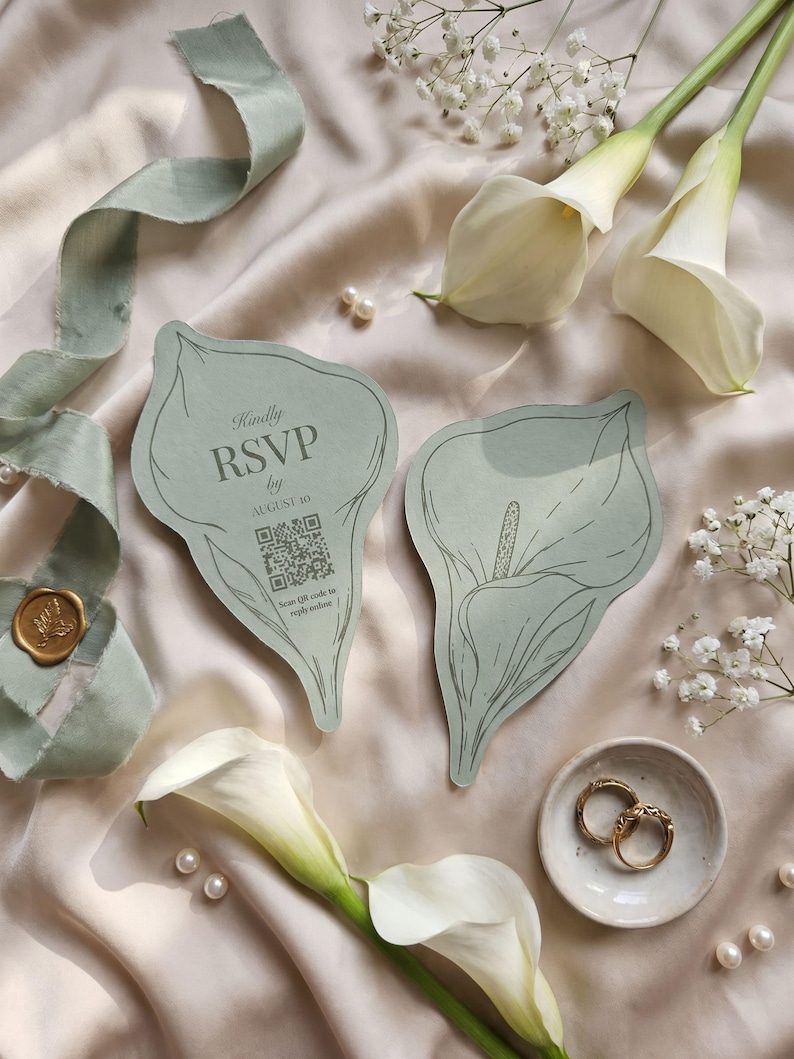 Puede incluir: Dos tarjetas de color verde salvia con forma de cala y dibujos de l&iacute;neas en verde oscuro. Una tarjeta muestra el texto 'Kindly RSVP by AUGUST 16' sobre un c&oacute;digo QR y la frase 'Scan QR code to reply online'. Las tarjetas se disponen con calas blancas.