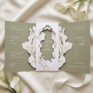 May include: A sage green tri-fold wedding invitation featuring a white die-cut centre band with calla lily illustrations. The text reads Kaylee and David, requesting the pleasure of your company at their wedding celebration on 08.02.28 at 3PM.