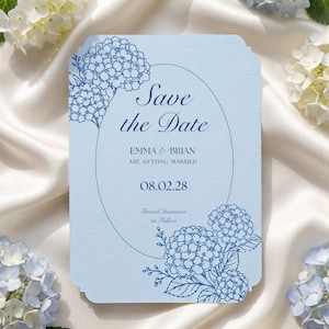 May include: A light blue rectangular Save the Date card with rounded corners, featuring dark blue line art of hydrangea flowers. The text reads Save the Date, Emma and Brian are getting married, 08.02.28, and Formal Invitation to Follow.