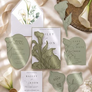 Puede incluir: Un conjunto de papeler&iacute;a de boda de siete piezas en cartulina verde salvia con ilustraciones de lirios cala blancos. El set incluye un men&uacute;, invitaci&oacute;n con funda floral troquelada, save the date, tarjeta RSVP, tarjeta de sitio y sobre con forro floral.