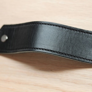 May include: Black leather drawer pull with silver rivets.