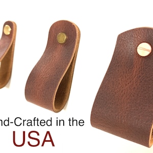 Op de afbeelding: Drie bruine lederen ladegrepen met messing beslag. Handgemaakt in de VS.