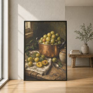 May include: A framed still life painting depicting a copper pot filled with yellow and green plums, resting on a wooden table next to a linen cloth, a small ceramic jar, and a metal spoon, with several loose plums scattered on the fabric.