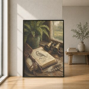 May include: A framed wall art print depicting a still life scene on a wooden windowsill. The composition includes a potted green fern, a pair of vintage brass binoculars, an open antique book with a bird illustration, and a single striped feather.
