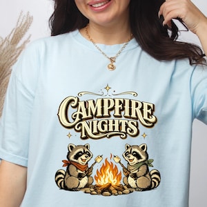 Retro illustration of two raccoons wearing bandanas roasting marshmallows over a campfire with the text Campfire Nights above them on a cream background. — product photo 8
