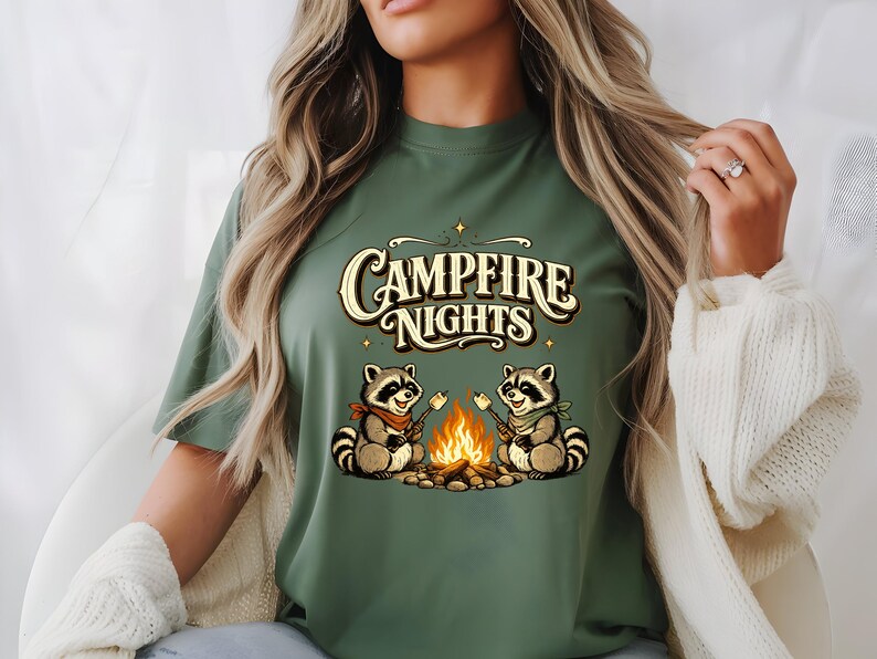 Retro illustration of two raccoons wearing bandanas roasting marshmallows over a campfire with the text Campfire Nights above them on a cream background. — product photo 13