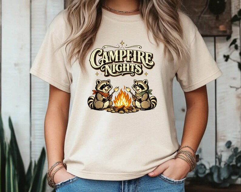 Retro illustration of two raccoons wearing bandanas roasting marshmallows over a campfire with the text Campfire Nights above them on a cream background. — product photo 7
