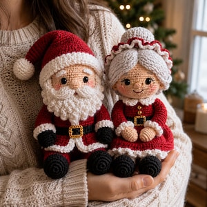 Puede incluir: Dos muñecos de ganchillo hechos a mano que representan a Santa Claus y a la Señora Claus. Santa lleva un traje rojo con barba y gorro blancos. La Señora Claus tiene el pelo gris, un gorro blanco y un vestido rojo. Botas negras y cinturones dorados.