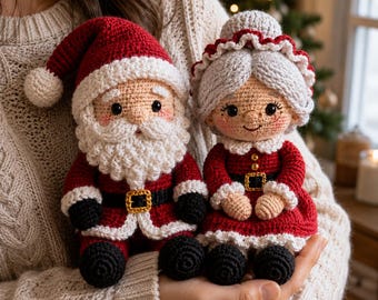 Könnte beinhalten: Zwei handgefertigte Häkelpuppen, die den Weihnachtsmann und Frau Weihnachtsmann darstellen. Der Weihnachtsmann trägt einen roten Anzug mit weißem Bart und Mütze. Frau Weihnachtsmann hat graues Haar, eine weiße Haube und ein rotes Kleid. Schwarze Stiefel und goldene Gürtel.