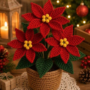 Könnte beinhalten: Eine gehäkelte Weihnachtsstern-Pflanze mit drei leuchtend roten Blüten mit gelben Zentren und dunkelgrünen Blättern, untergebracht in einem strukturierten, beigefarbenen gehäkelten Topf. Die Pflanze steht auf einer cremefarbenen Häkeldecke.