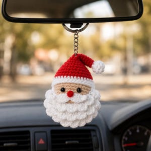 Może przedstawiać: Szydełkowana ozdoba w kształcie Świętego Mikołaja zawieszona na srebrnym metalowym kółku do kluczy. Figurka posiada czerwoną czapkę z białym pomponem, beżową twarz, czarne koralikowe oczy, mały czerwony nos oraz białą brodę z szydełkowych oczek.