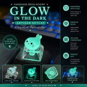 Op de afbeelding: Een handgemaakte artisanale hars keycap met een lichtblauw zeehondontwerp dat oplicht in het donker. De keycap is compatibel met MX-stelen en toont de tekst: HANDMADE RESIN KEYCAP GLOW IN THE DARK, Tiny details. Big personality. en GLOWS SUPER BRIGHT IN THE DARK!