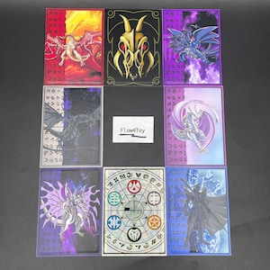 Peut inclure: Huit protège-cartes rectangulaires présentant diverses illustrations fantastiques, dont des dragons, un crâne doré et un sceau magique circulaire. Une petite étiquette en papier blanc au centre affiche le texte Flow4Toy imprimé en noir.