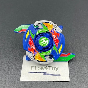 May include: A blue, green, and silver Oranzer Metal Flame Beyblade spinning top toy featuring a central green emblem with a bird graphic, red and orange flame patterns, and the text Oranzer Metal Flame and OZ on the top surface.