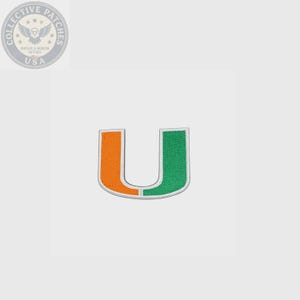 May include: An embroidered patch in the shape of the letter U, featuring a split design with an orange left side and a green right side, outlined in white thread. The patch has a textured surface and a clean, bold aesthetic for application.