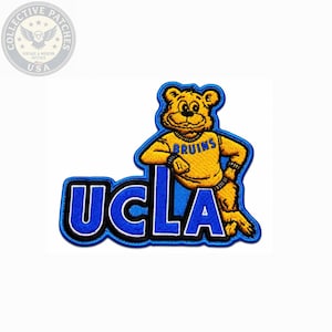May include: An embroidered patch featuring the UCLA logo in blue and white, with a yellow bear mascot wearing a yellow sweater that says BRUINS in blue letters. The bear is leaning against the large blue letters spelling out UCLA with white outlines.