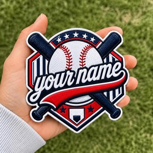 May include: A circular embroidered patch featuring a white baseball with red stitching, crossed dark blue baseball bats, and a home plate icon. The design includes red and blue borders, white stars, and the text "your name" in white script.