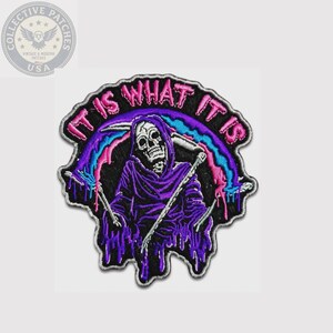 May include: An embroidered patch featuring a skull figure in a purple hooded robe holding a scythe. The design includes a dripping rainbow arc and the text IT IS WHAT IT IS in pink letters. The patch has a black background and a white border.