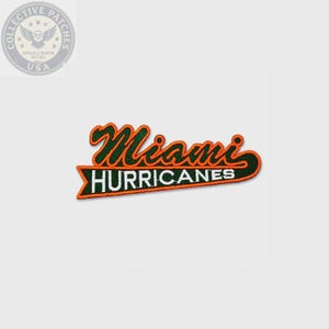 May include: An embroidered patch featuring the word Miami in green script with an orange outline, positioned above the word HURRICANES in white block letters on a green pennant-shaped background with an orange border and a pointed tail.