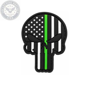 May include: A skull-shaped patch featuring a stylized American flag design. The upper left quadrant displays white stars on a black background, while the rest of the skull is composed of vertical black and white stripes with a single bright green stripe.