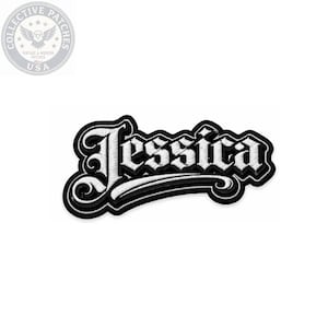 Peut inclure: Un écusson brodé affichant le prénom Jessica dans une police de style gothique blanche avec une bordure noire épaisse et un fond noir. Les lettres présentent une fioriture stylisée distincte au début et à la fin, créant un design contrasté.